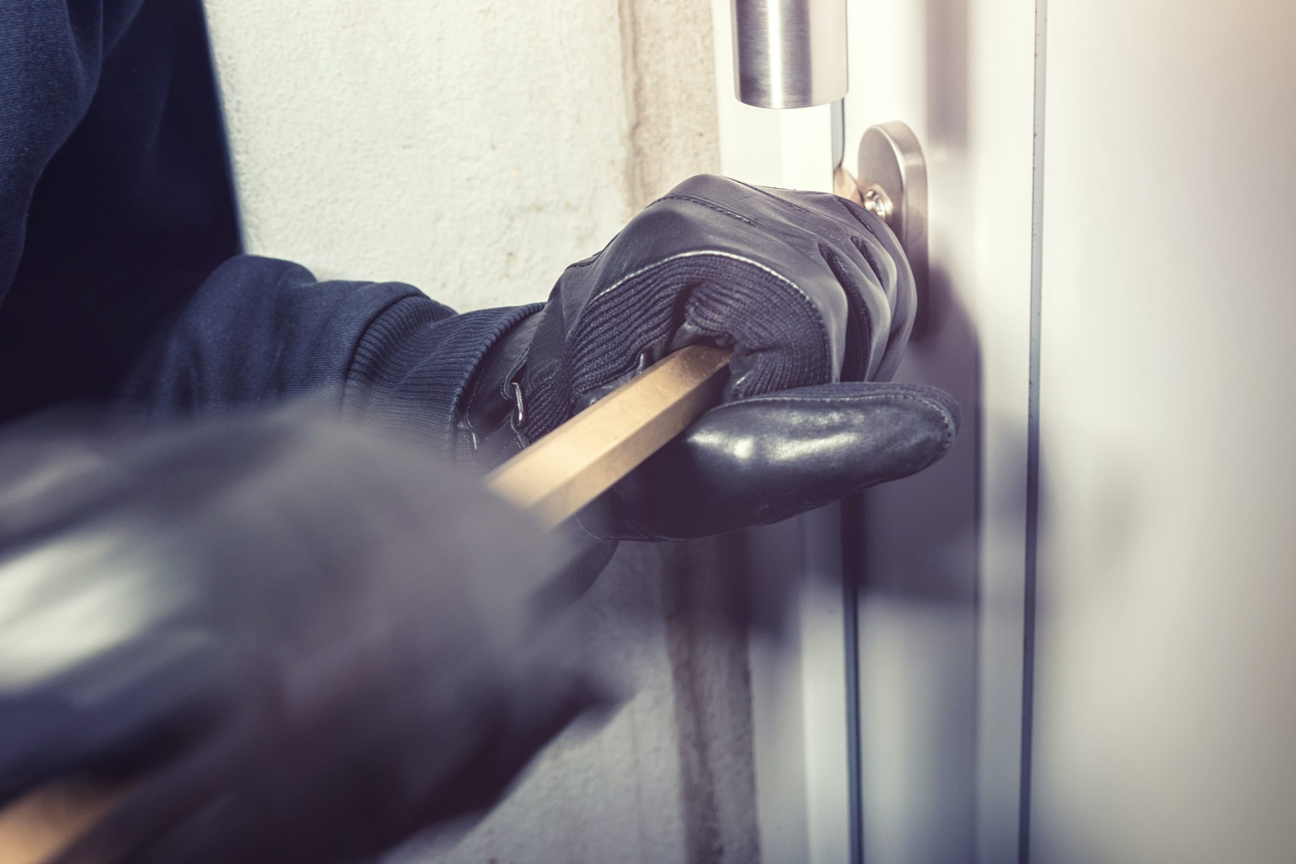A burglar forcing a door with a crowbar